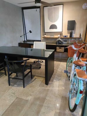 Eine moderne Küche mit einer großen Kochinsel, einem Esstisch mit Stühlen und einem Fahrrad mit Korb.
