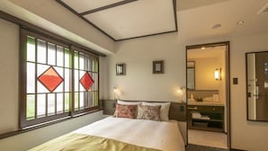 A hotel room with a bed, a window with stained glass, a mirror, and a bathroom visible through an open door. - HOTEL ARU KYOTO (Kyoto)