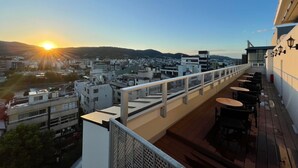 A rooftop terrace with a view of a cityscape during sunset. - HOTEL ARU KYOTO (Kyoto)