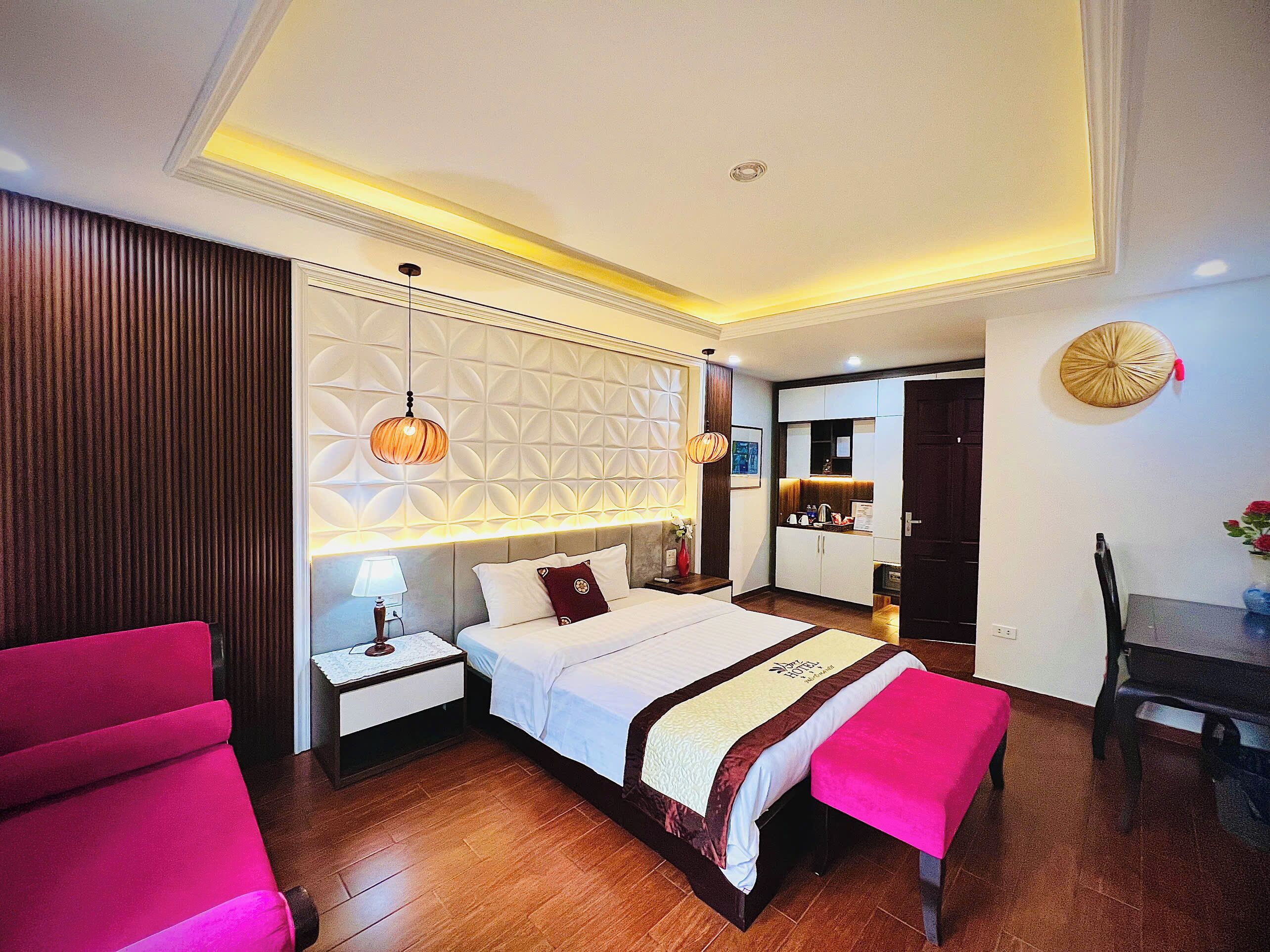 A hotel room with a bed, bedside tables, a desk, a chair, and a mirror.