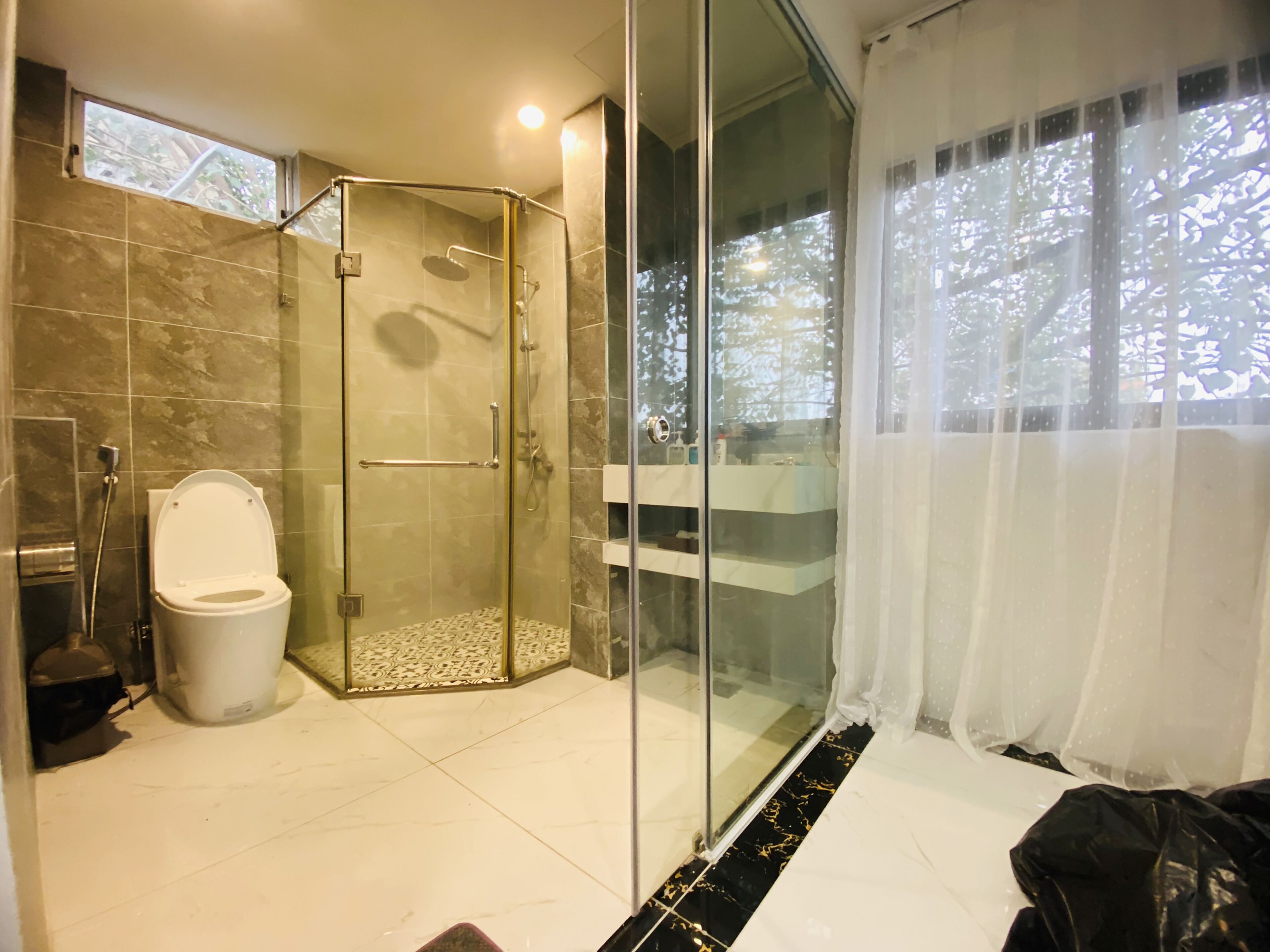 Ein modernes Badezimmer mit einer Duschkabine, einer Toilette und einem Waschtisch mit Spiegel.