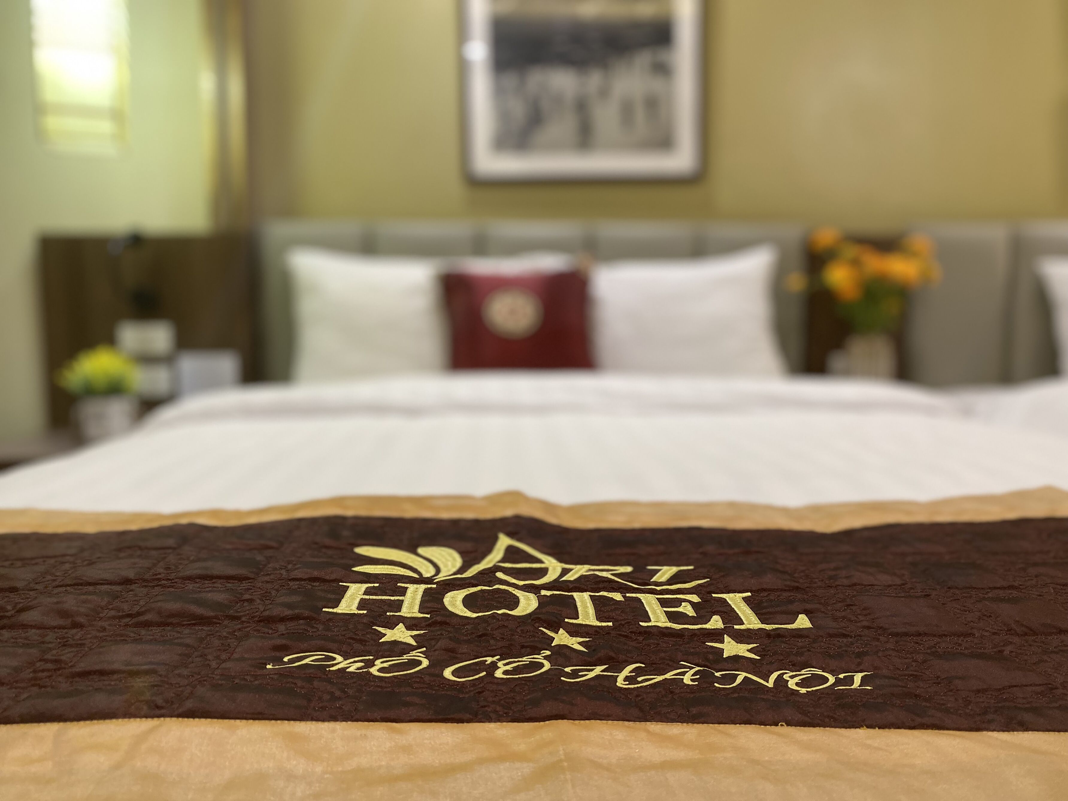 Un lit d’hôtel avec une tête de lit marron et un coussin décoratif.