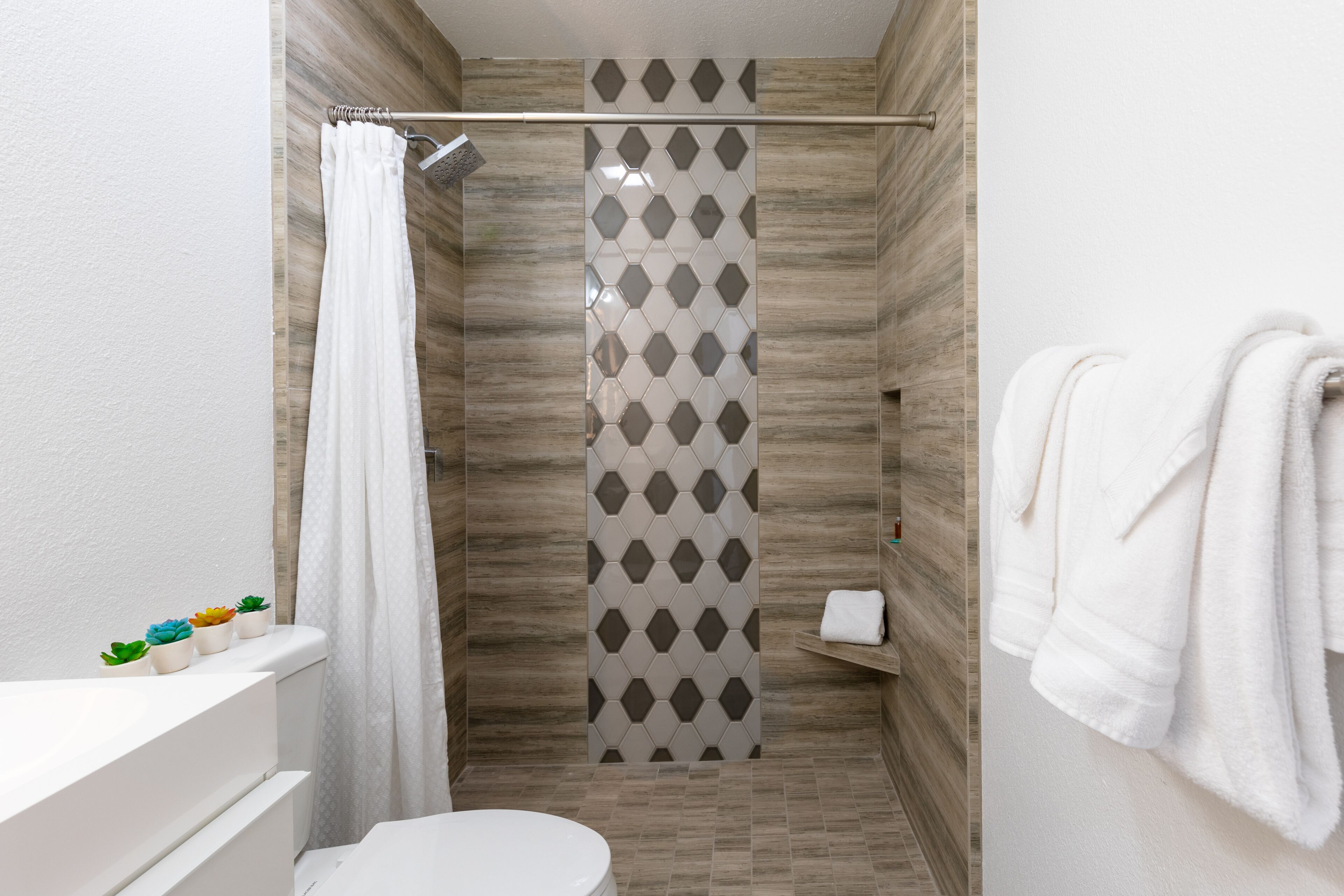 Une salle de bain avec une douche, des toilettes et un porte-serviettes.