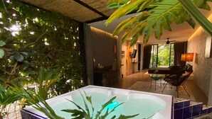 A spa area with a hot tub, surrounded by tropical plants and a tiled floor. - ECOPARADISE (Pereira)