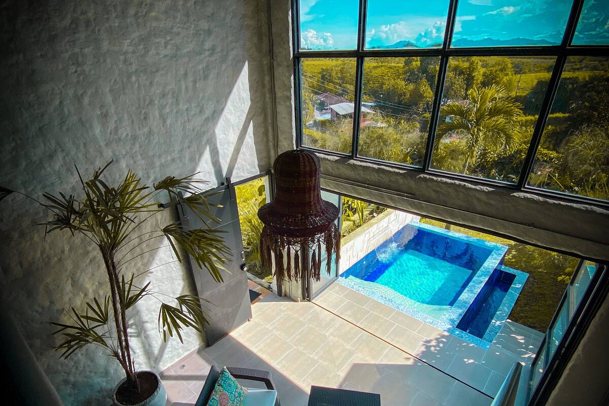 A balcony with a view of a swimming pool and a garden.