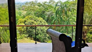Un balcon donnant sur un paysage verdoyant et luxuriant.