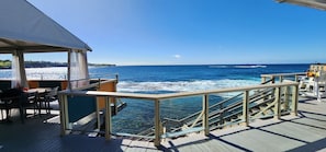 Enjoy the ocean view from the deck, which features a table, chairs, and a covered seating area.