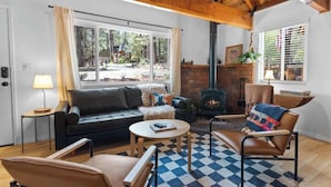 A cozy living room with a fireplace, a sofa, a coffee table, and a chair.