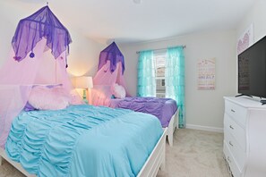 Ein Schlafzimmer mit zwei Betten, jeweils mit Baldachin, einem Schminktisch und einem Fernseher.