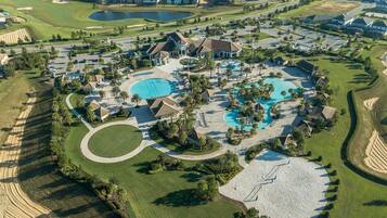 An aerial view of a resort with multiple swimming pools, golf courses, and residential buildings.