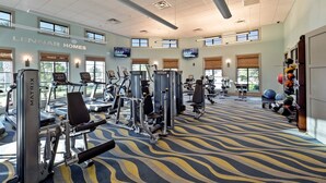 Ein Fitnessstudio mit Laufbändern, Kraftgeräten und Trainingsbällen.