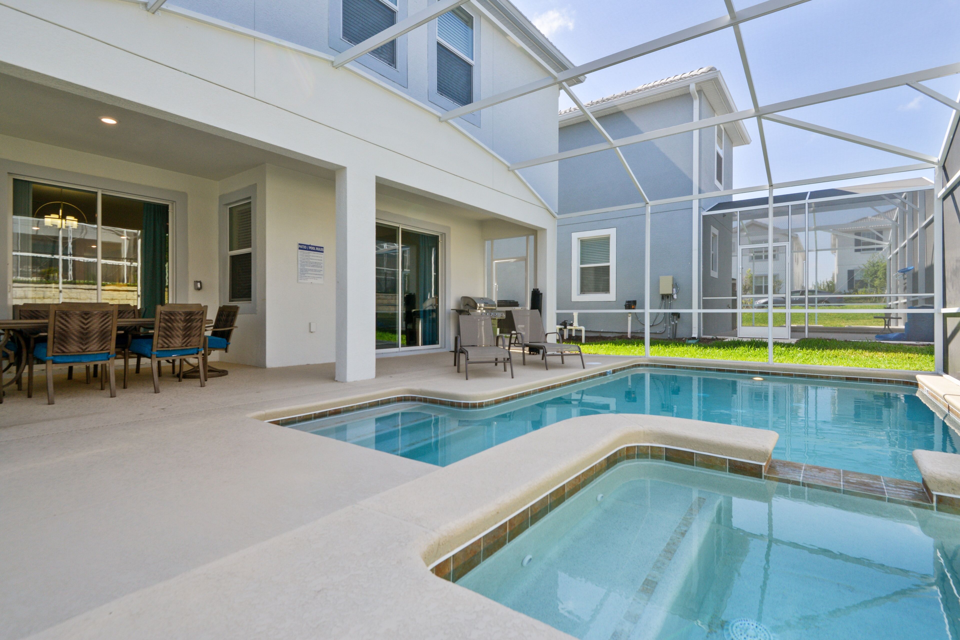 Zona de piscina con terraza cubierta, mobiliario exterior y vistas del paisaje circundante.