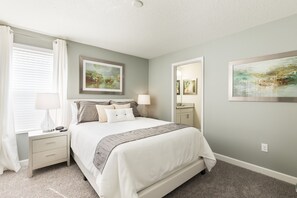 A neatly arranged bedroom with a bed, bedside tables, and artwork on the walls. - 1516mb- The Retreat At Championsgate 6 Bedroom Home by RedAwning (Davenport)