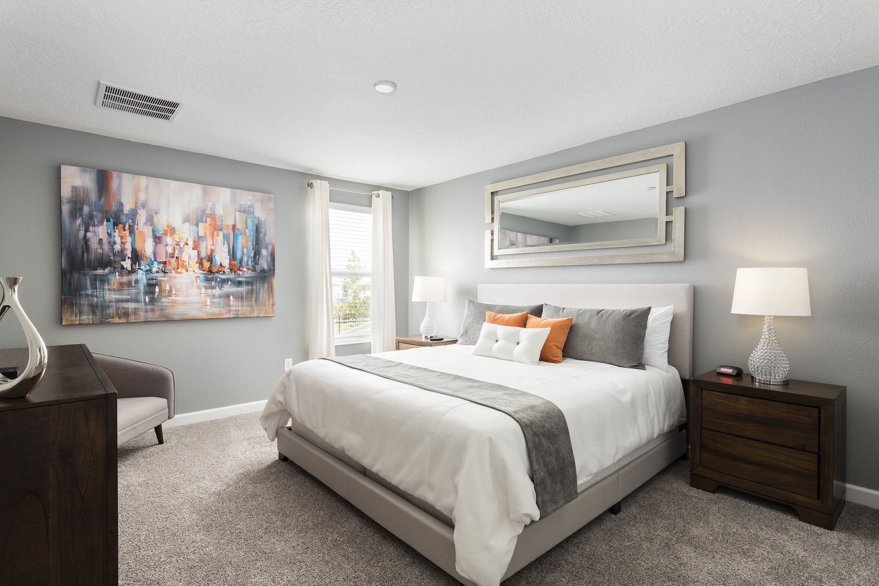 A bedroom with a large bed, bedside tables, a dresser, a painting, and a window with curtains.