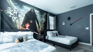 A bedroom with two beds, Star Wars-themed decor, and a mural of Stormtroopers.