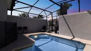 A swimming pool with a glass enclosure, surrounded by lounge chairs and a patio area. - 1589mvd-the Retreat At Championsgate 4 Bedroom Townhouse by RedAwning (Davenport)