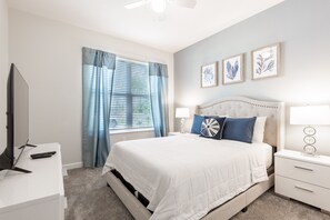 A bedroom with a bed, nightstands, a TV, and a ceiling fan. - 601dsd-the Retreat At Championsgate 5 Bedroom Home by RedAwning (Kissimmee)
