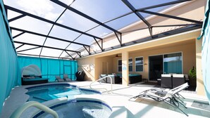 A swimming pool area with a glass ceiling, lounge chairs, and a sunbed. - 7547oml-solterra Resort 6 Bedroom Home by RedAwning (Davenport)