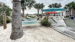 A beachside area with hammocks, umbrellas, and lounge chairs. - 2127lc- Windsor Island 10 Bedroom Home by RedAwning (Davenport)