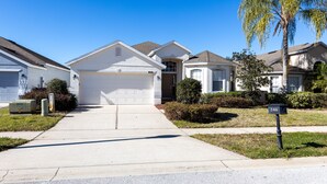A suburban neighborhood with single-family homes, a clear sky, and a mailbox with the number 246. - 246bd-highlands Reserve 4 Bedroom Home by RedAwning (Davenport)