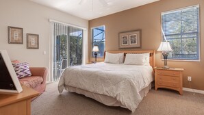 A bedroom with a bed, a nightstand, a lamp, a chair, a desk, and a window with blinds. - 246bd-highlands Reserve 4 Bedroom Home by RedAwning (Davenport)