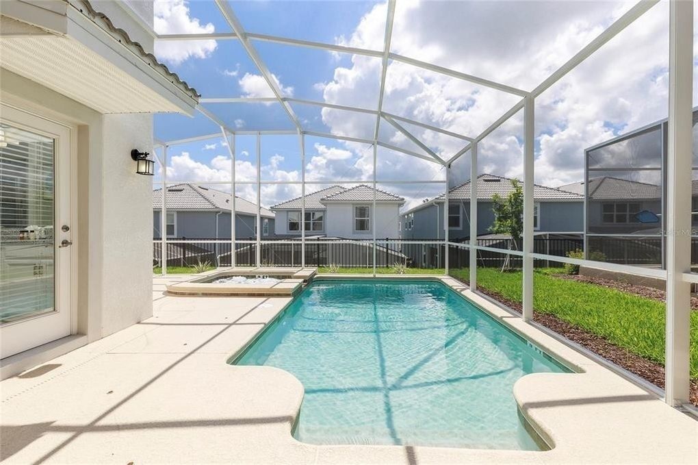 A covered outdoor swimming pool with a clear view of houses in the background.