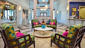 A spacious living area with a high ceiling, large windows, and a central round table. - 8973ccd - The Retreat At Championsgate 4 Bedroom Townhouse by RedAwning (Kissimmee)