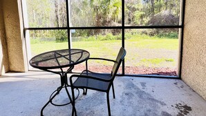 A room with a large window, a round table, and a single chair. - 1301tt Unit 9108- Tuscana Resort 3 Bedroom Condo by RedAwning (Davenport)