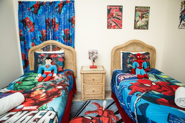 A bedroom with two beds, each covered with a Spider-Man themed duvet. There are two posters on the wall, one of Batman and one of Spider-Man. - 777bd - West Haven Gated Community 4 Bedroom Home by RedAwning (Davenport)