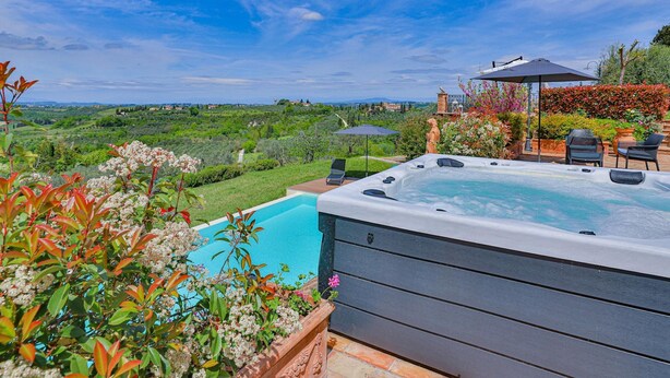 A hot tub with a view of a lush landscape, outdoor seating, and a statue. - Villa in Certaldo ID 4125 (Certaldo)