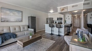 Un salon moderne avec un canapé, une table basse et un tableau accroché au mur.