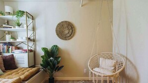 A cozy room with a bed, a hanging chair, a bookshelf, and a potted plant. - Lamont 1 2bed Pet-Friendly Apt (Johnson City)