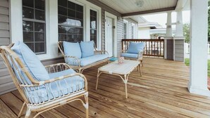 A covered porch with wicker furniture and a wooden deck. - Lamont 1 2bed Pet-Friendly Apt (Johnson City)
