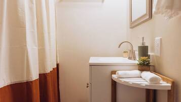 A bathroom with a white sink, a mirror, and a towel rack.