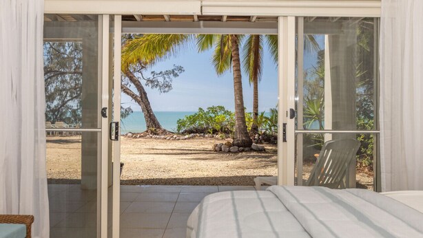 Un dormitorio con puerta corrediza de vidrio que da a vista al mar.