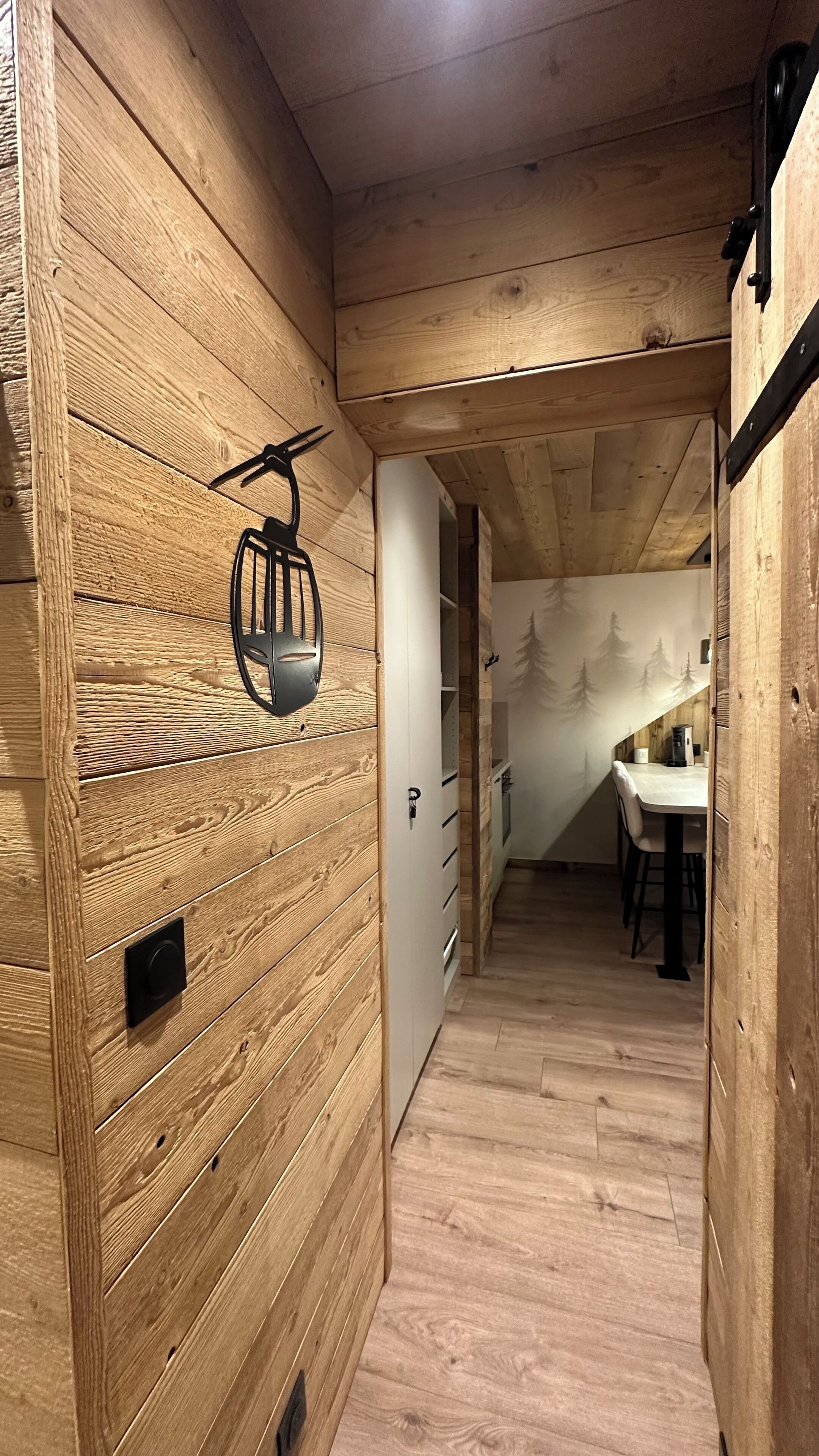 Un intérieur en bois comprenant un espace cuisine, avec une table et des chaises.