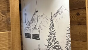 A room with wooden walls, a white ceiling, and a mural of a mountain scene with a ski lift. - Appartement Samoëns (Samoëns)