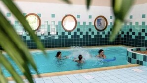 An indoor swimming pool with tiled walls and a tiled floor. - Appartement Samoëns (Samoëns)