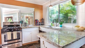 A kitchen with a stove, oven, and countertop. - Sunrise Tropical Garden Getaway (Pahoa)