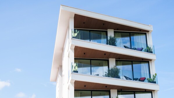 A modern multi-story building with large windows and balconies.