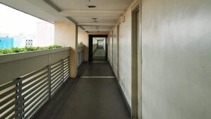 A long, narrow corridor with a metal railing on one side and a door on the other. - 150 Newport condotel pasay  (Pasay)