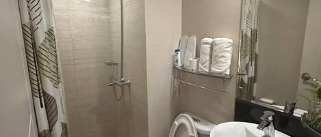 Un baño moderno con ducha, inodoro y lavamanos.