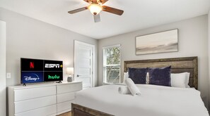 Relax in comfort with a large bed, flat-screen TV, and ceiling fan.
