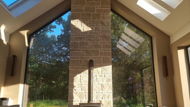 A cozy room with a stone fireplace, large windows, and a comfortable seating area. - Exceptional New Beautiful House in Trossachs Loch Lomond National P. Brig O Turk (Callander)