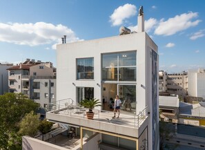 Un bâtiment moderne à deux étages, doté de grandes fenêtres, d’un balcon et d’une cheminée.