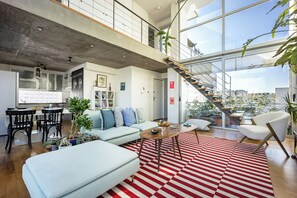 A modern living room with a sofa, coffee table, and a red and white striped rug.