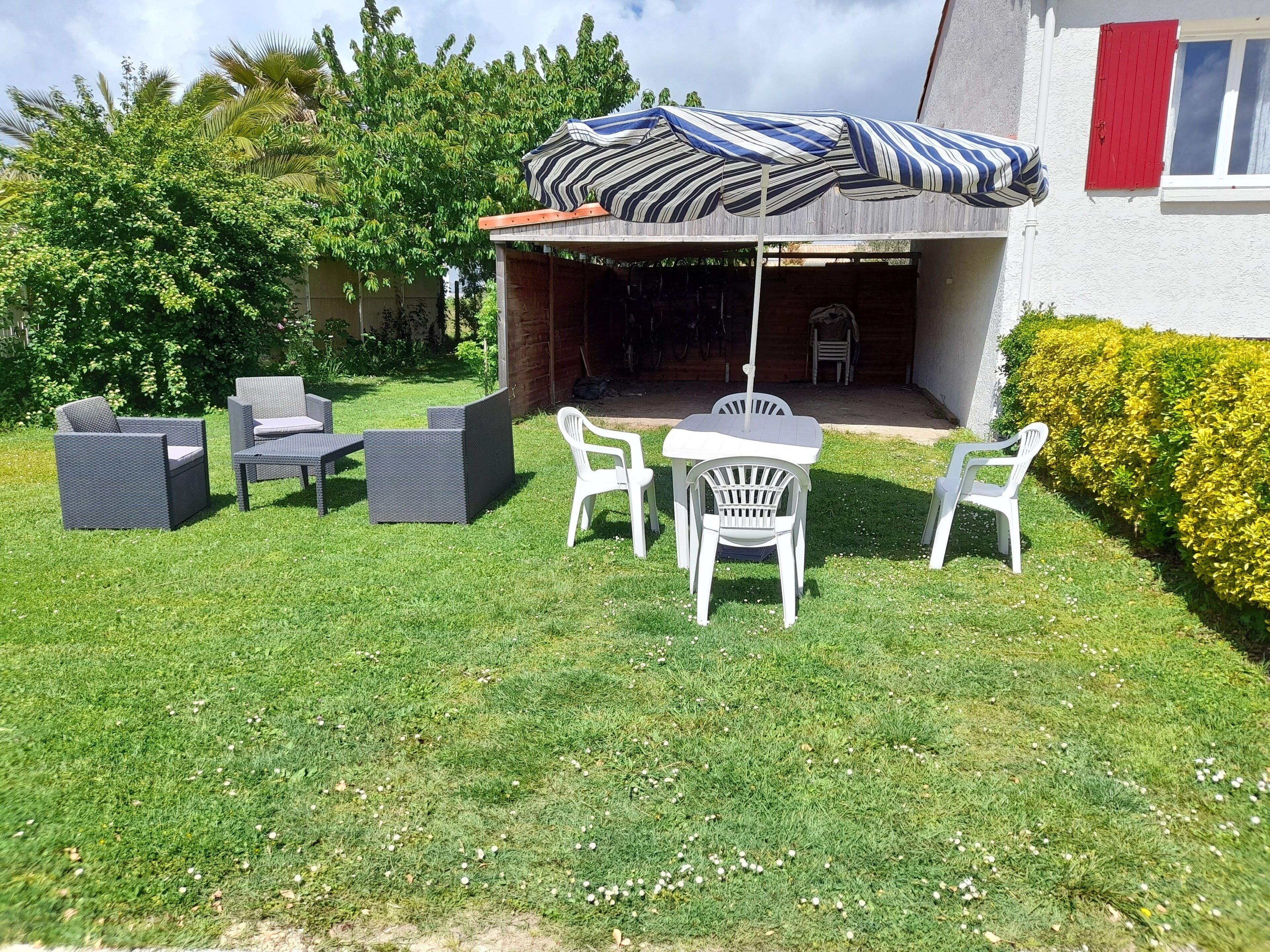 A patio area with outdoor furniture, a covered seating area, and a well-maintained lawn.