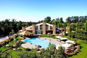 A resort with a swimming pool, sun loungers, and umbrellas.