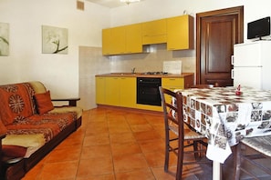 A compact living space with a kitchenette, a dining area, and a sofa.