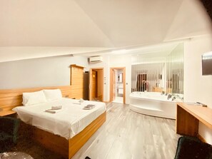 A modern hotel room with a large bed, a separate bathroom with a bathtub, and a mirror. - Waves Hotel (Istanbul)